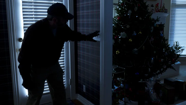 Burglar breaking into apartment during holidays.