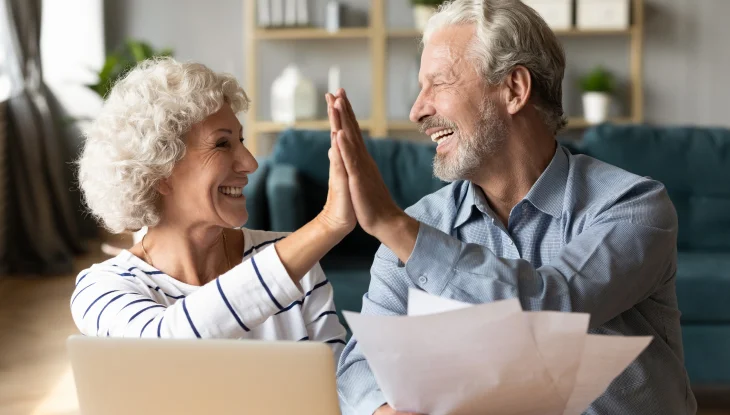 Happy smiling senior couple gives a high five.