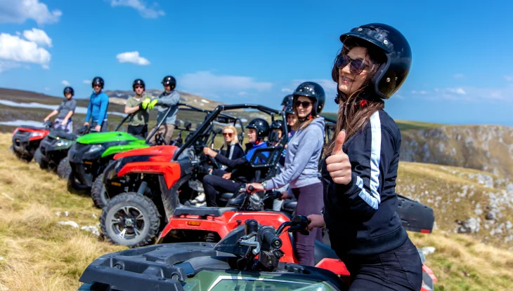 A group of ATV riders, young woman with thumbs up.