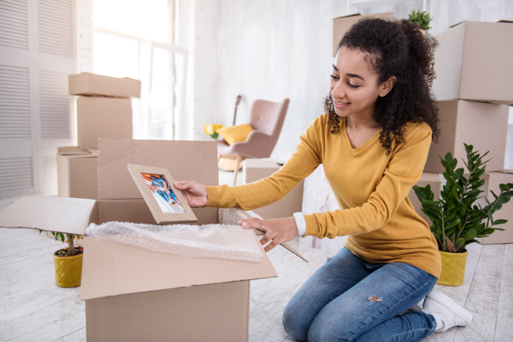 Young smiling African American woman unpacking boxes