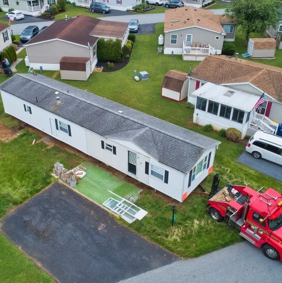 Aerial view of a mobile home being moved out of a mobile home park.