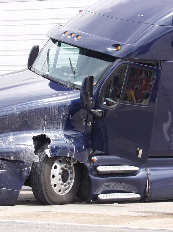 Truck drivers stands beside his semi talking on the phone after a wreck, cheap commercial truck insurance in Georgia.