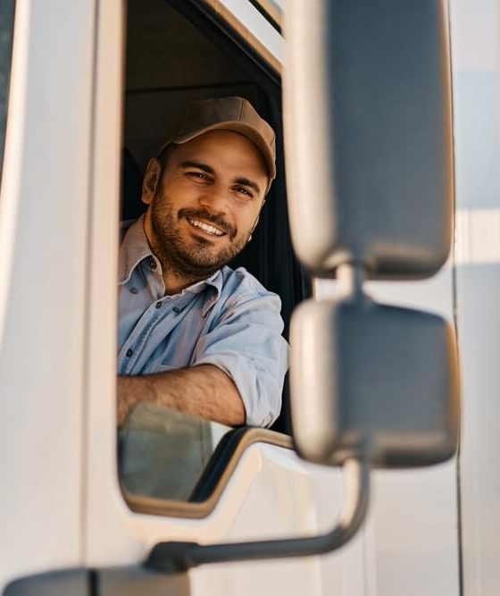 Driver on their semi truck smiling because of their affordable commercial auto insurance - Cheap auto insurance in Georgia