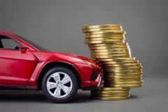 Toy red car crashing into row of coins - Velox, cheap car insurance in Georgia