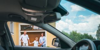 Family of 3, mom, dad, and son seen from the window of their insured car - Velox, cheap auto insurance in Georgia.