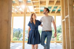 Couple walks through their framed out home.