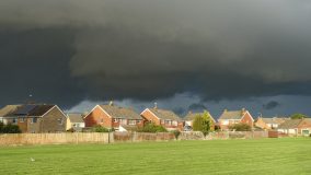 A storm brews over a row of homes.