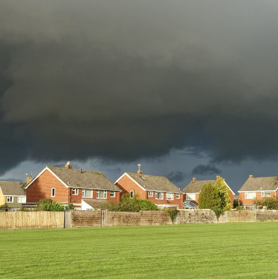 A storm brews over a row of homes.