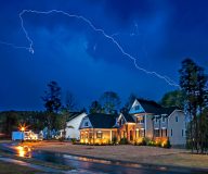 Lightening breaks over homes in Atlanta during a storm - cheap home insurance in Atlanta, Georgia.