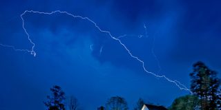 Lightening breaks over homes in Atlanta during a storm - cheap home insurance in Atlanta, Georgia.