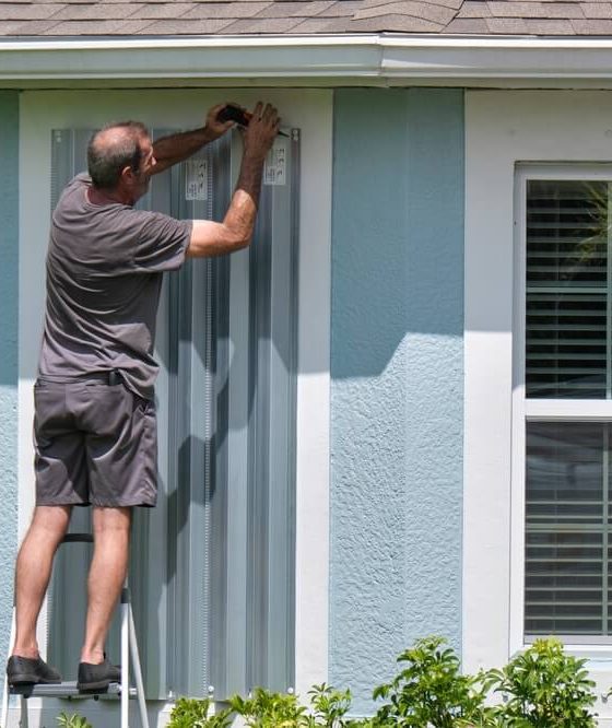 Putting up storm windows before a major storm hits - cheap homeowners insurance in Georgia.