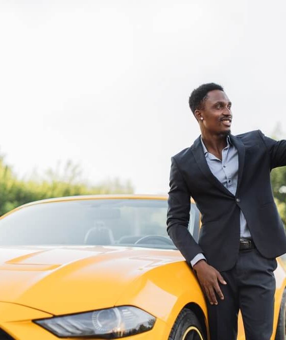 Handsome young man takes a selfie in front of his sports car - cheap car insurance in Georgia.