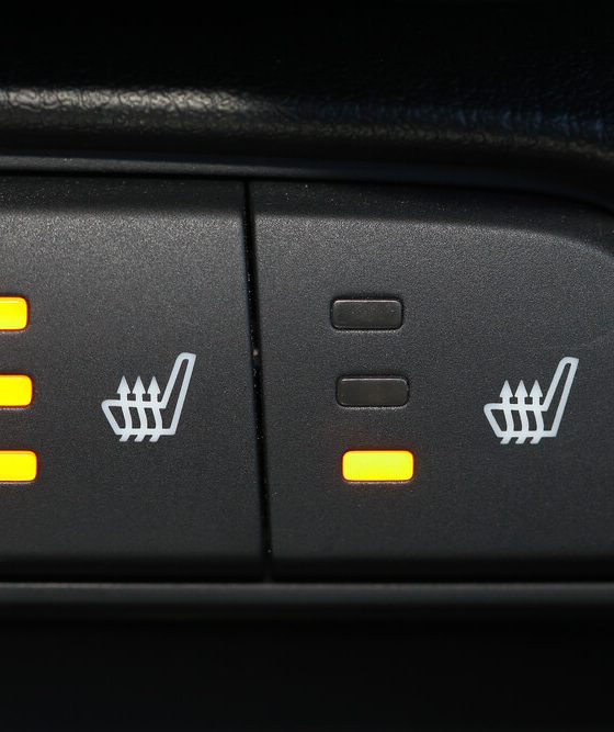 An image shows icons on a car dashboard indicating seat warming technology - cheapest car insurance in Georgia.