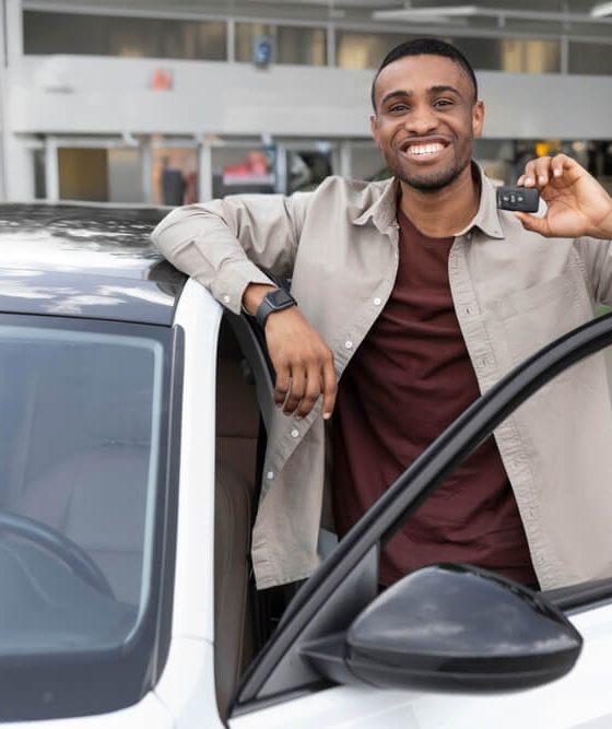 A smiling man shows off the car he has for sale in Georgia.