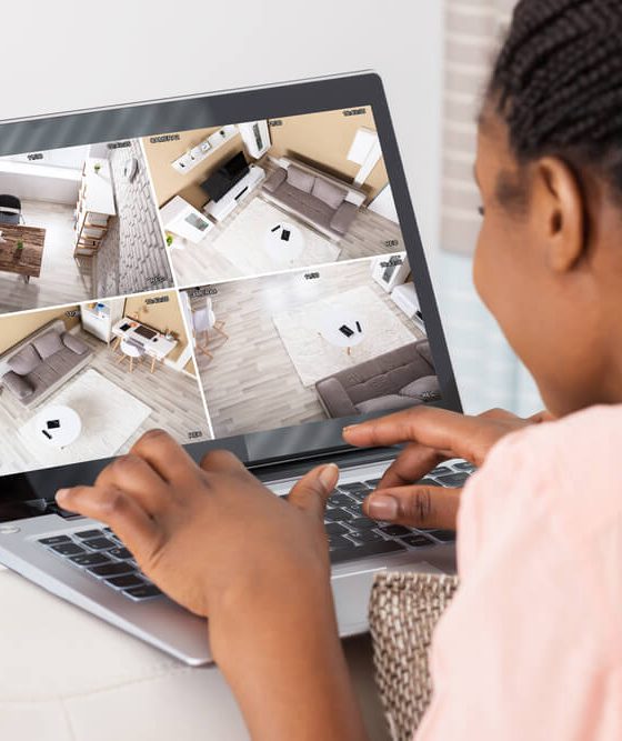A woman monitors her home while on vacation through her laptop - cheap home insurance in Georgia.