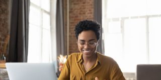 Business woman sits at her computer, smiling, because her business is protected with business insurance in Georgia.
