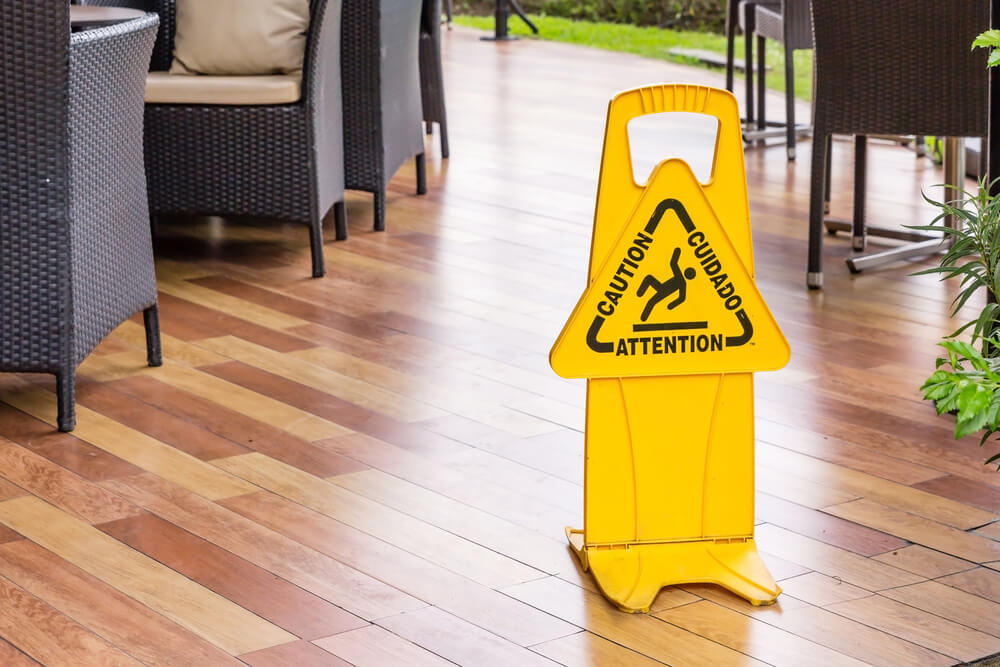 A sign is on the floor of a business alerting customers the floor is wet and is a slip hazard - cheap business insurance in Georgia.