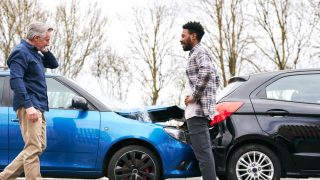 Senior and younger male drivers get out of cars and inspect damage after road traffic accident, what to do after a car accident, cheap car insurance in Georgia.