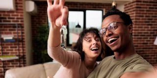 New homeowner couple holding their key and a box just moved in and purchased homeowners insurance