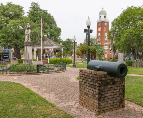 The Willis Park square with colonial cannons, a gazebo, walkways, and historic buildings: Cheap car insurance in Bainbridge, Georgia.