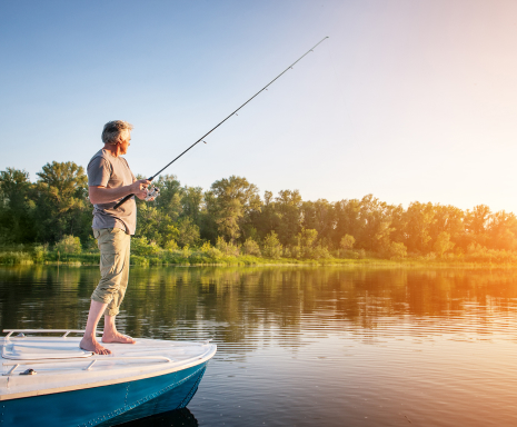 Mature man on a motorboat, fishing on a lake: Cheap auto insurance in LaGrange, Georgia.