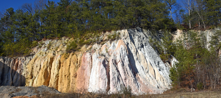 Abandoned quarry with colorful mineral deposits, with natural erosion on a cliff hillside.